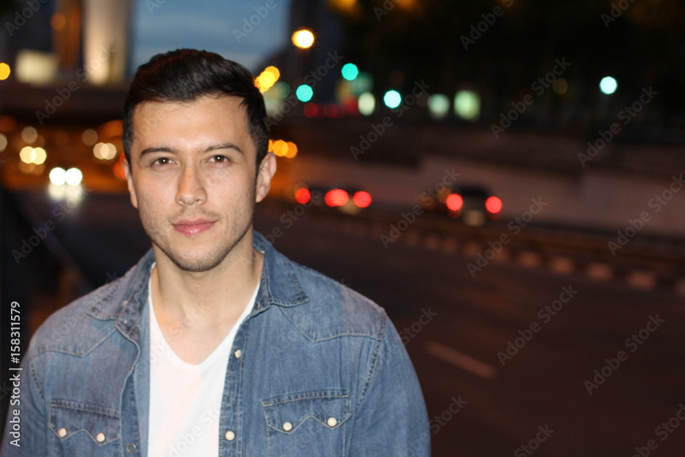 Handsome ethnic man in the city at night with copy space Handsome ethnic man in the city at night with copy space