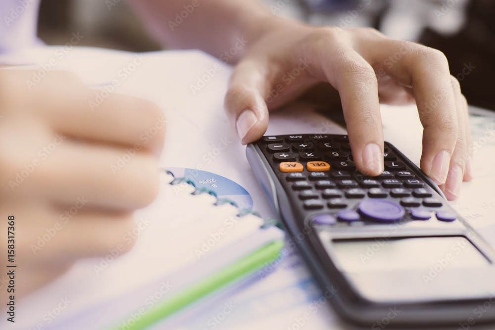Close up Business man using calculator and laptop computer for calculating with finance paper, tax, accounting, Accountant concept. Close up Business man using calculator and laptop computer for calculating with finance paper, tax, accounting, Accountant concept.