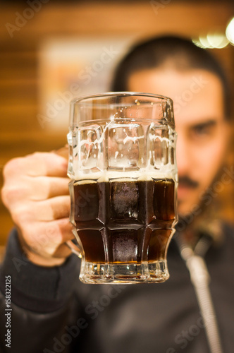 Man dolding a dark beer, delicious craft beer Booze Brew Alcohol Celebrate