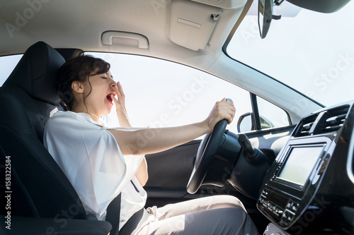 yawning female driver. falling asleep at the wheel concept.