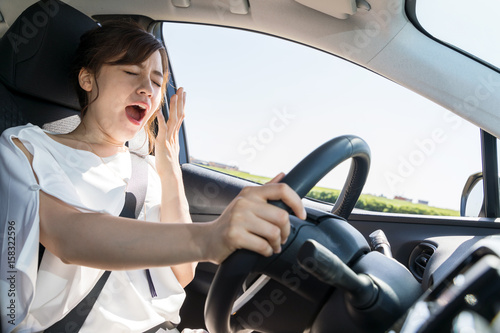 yawning female driver. falling asleep at the wheel concept.