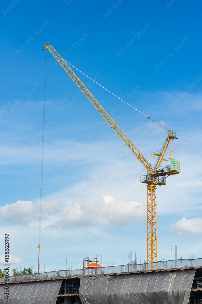Yellow construction crane with blue sky in Bangkok, Thailand