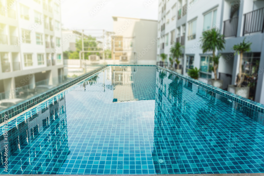 Blur high rise condominium buildings and focus swimming pool.
