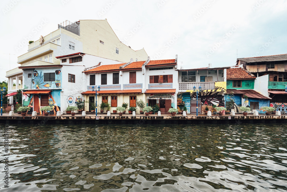 Colorful chinese colonial buildings decorated with wall art painted near the river in Malacca City, Malacca, Malaysia.