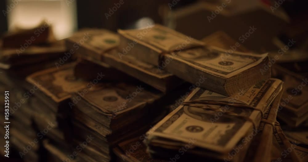 Bundles of cash on the table. Dolly shot of pile of American banknotes, bundle of money. US Dollar is official currency of United States