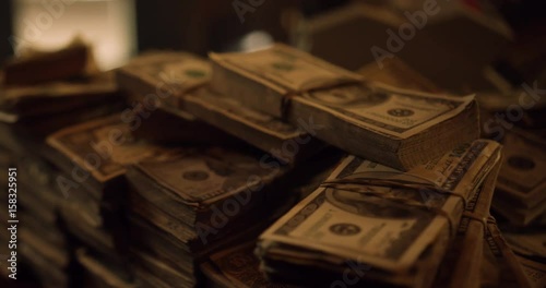Bundles of cash on the table. Dolly shot of pile of American banknotes, bundle of money. US Dollar is official currency of United States