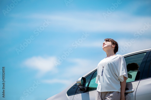woman driver and vehicle under the blue sky.