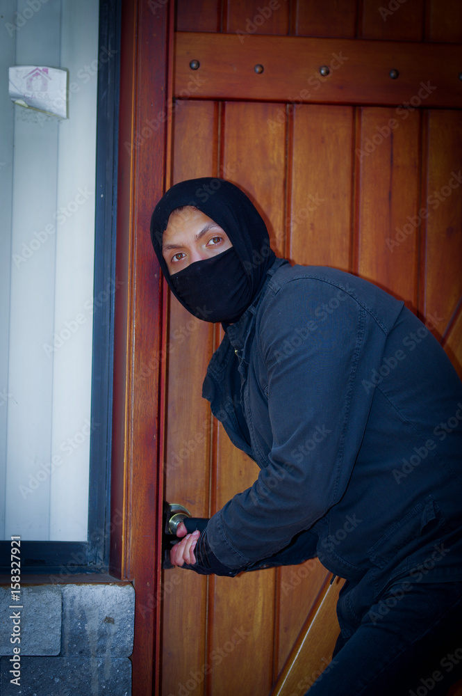 Burglar with wearing a mask trying to enter the house Burglar with wearing a mask trying to enter the house