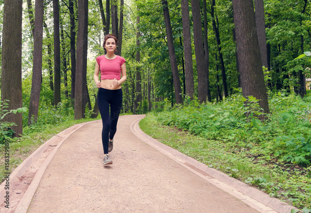 Young woman running down the road in the forest. Instagram