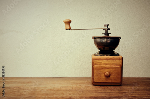Old coffee grinder, manual hand mill on the table. vintage style.