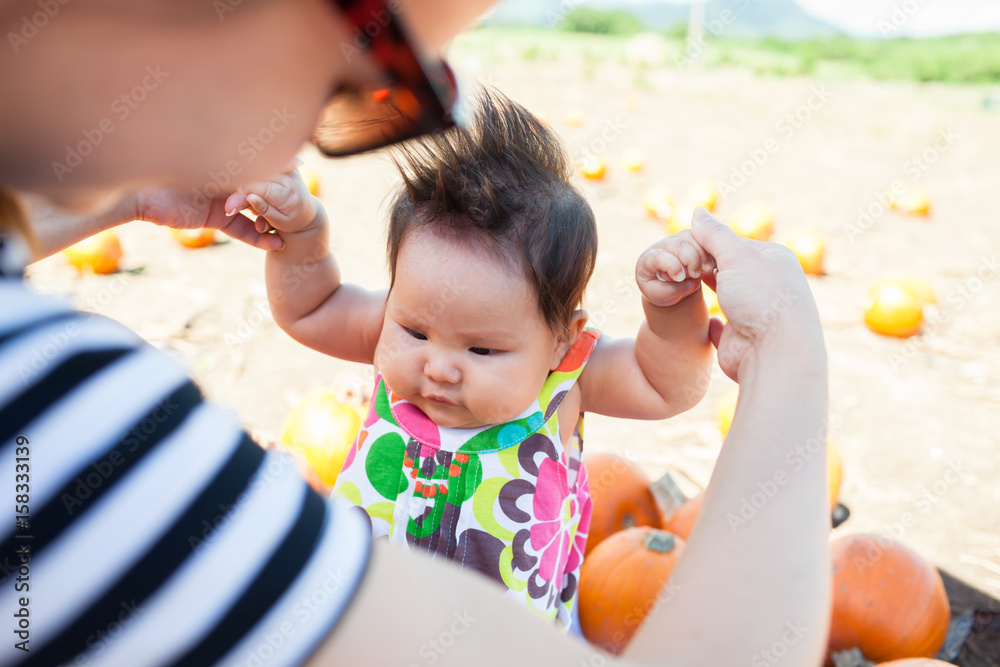 Mother and child choosing a pumpkin at the local pumpkin patch for the holidays Mother and child choosing a pumpkin at the local pumpkin patch for the holidays
