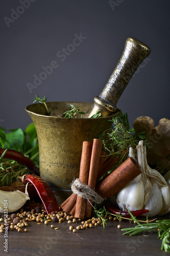 Different herbs and spices on a wooden table .