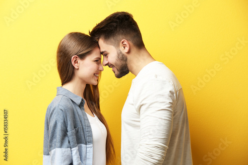 Cute young couple on color ...