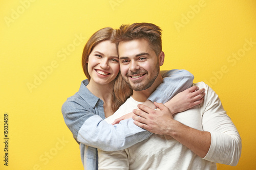 Cute young couple on color ...