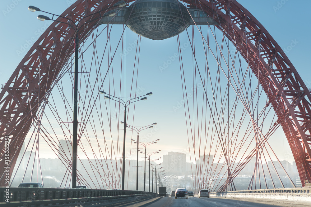 Obraz premium winter road goes under the red bridge. frosty winter highway.