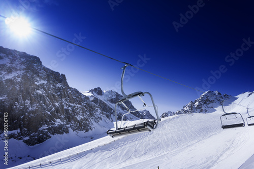 Winter mountains, panorama - snow-capped peaks. Ski lift. photo