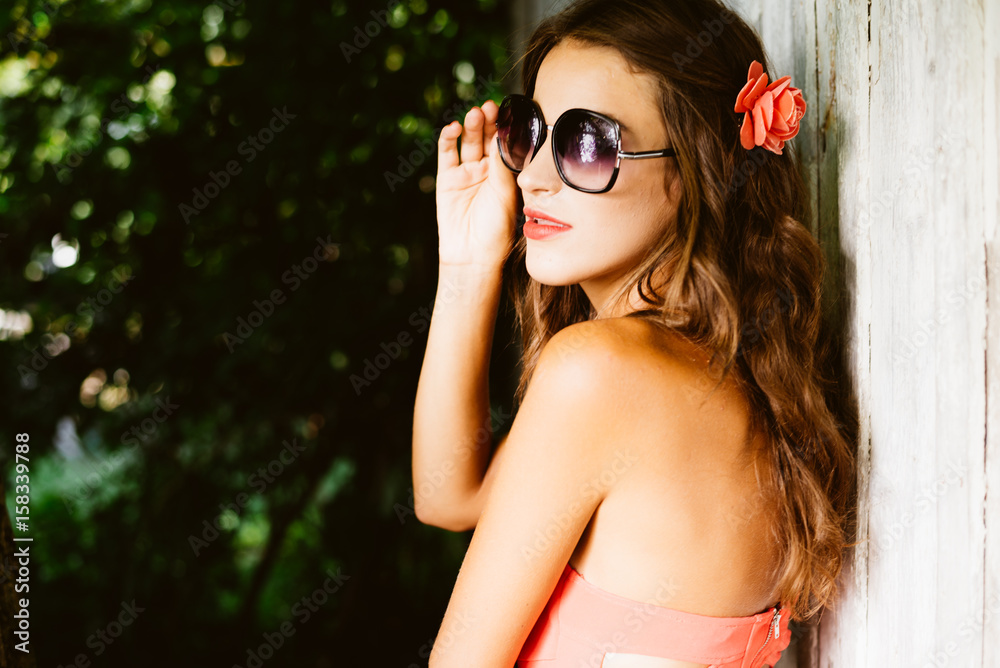 Young sexy stylish lady in front of wooden door on a sunny summer day. Lifestyle outdoor portrait background Young sexy stylish lady in front of wooden door on a sunny summer day. Lifestyle outdoor portrait background