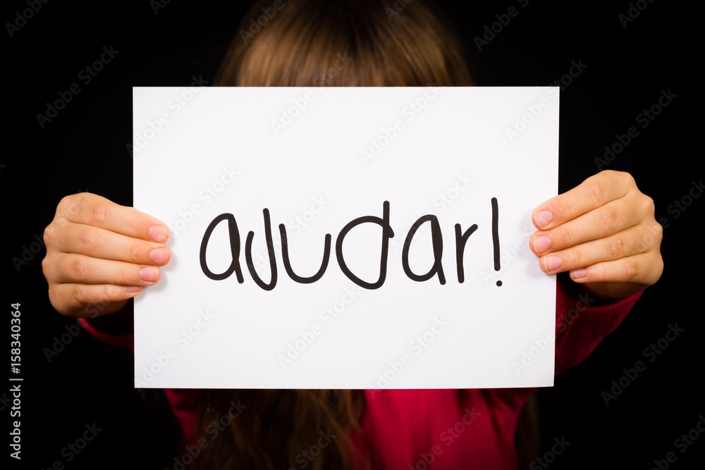 Child holding sign with Portuguese word Ajudar - Help Child holding sign with Portuguese word Ajudar - Help