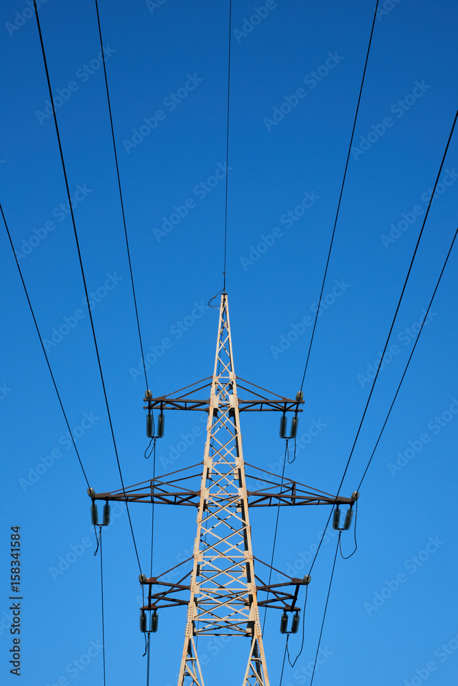 The support of the high-voltage transmission line against the blue sky