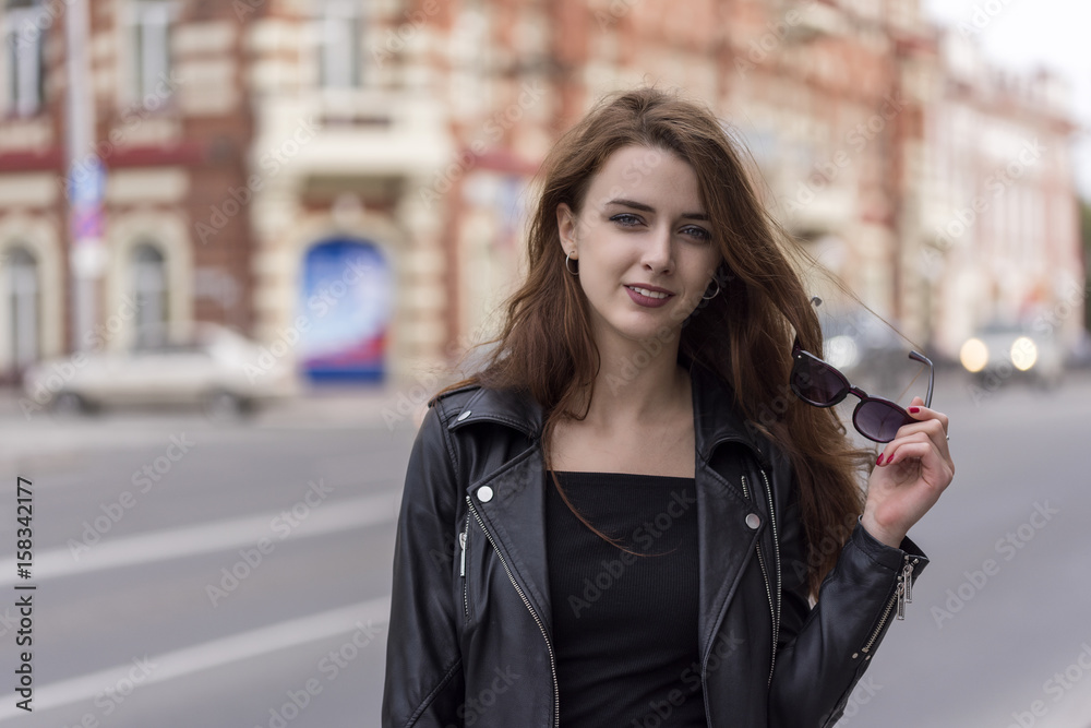 Girl with long hair posing on city street