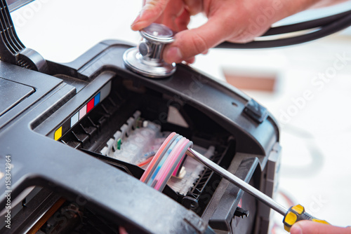 Repairman repairing broken color printer
