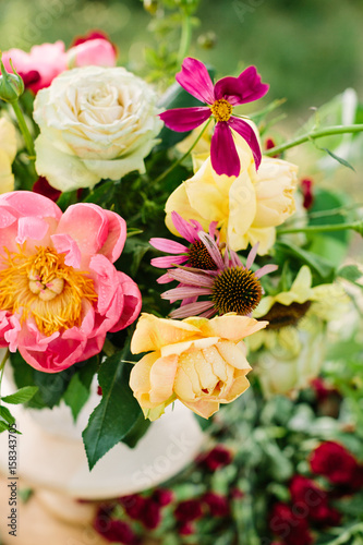 bouquet, holidays flower, floral arrangement concept - top view on flowers and buds in a pretty bouquet of pink peons, yellow and white roses, purple daisies and red carnations © melnikofd