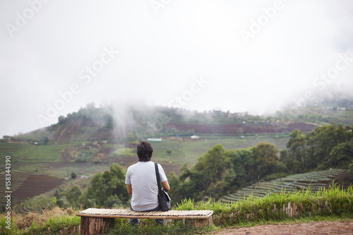 Man watching scenic natural beauty with mountains and fog.