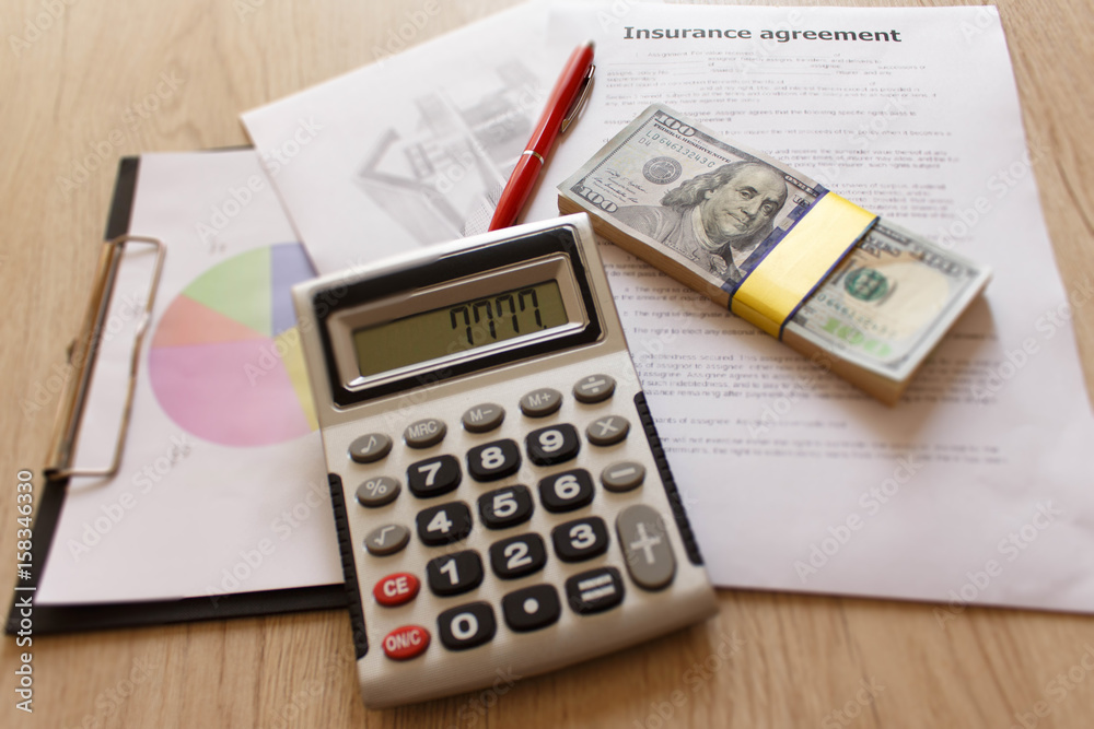 Insurance form with pen, dollars, calculator on the table. Homeowner insurance policy Insurance form with pen, dollars, calculator on the table. Homeowner insurance policy