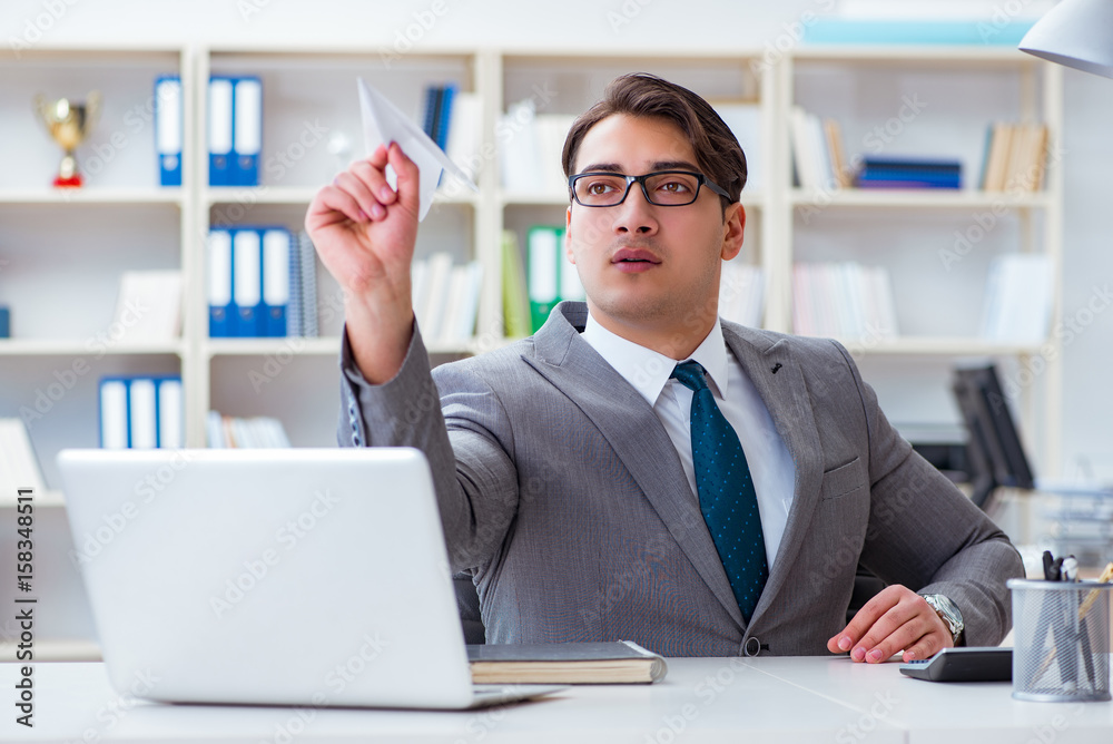Businessman with paper airplane in office Businessman with paper airplane in office
