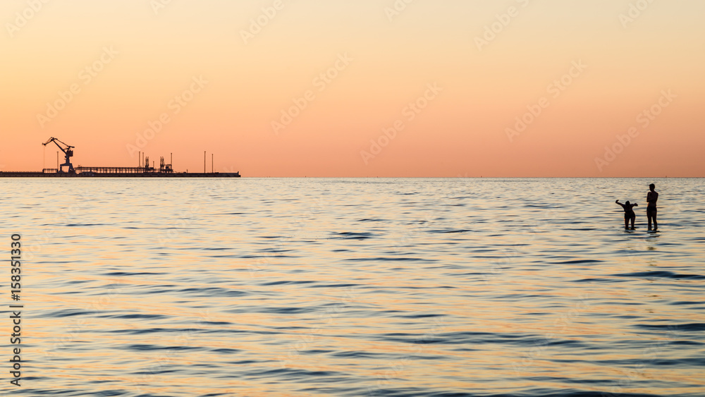 Fototapeta premium Couple bathing at sunset in the sea