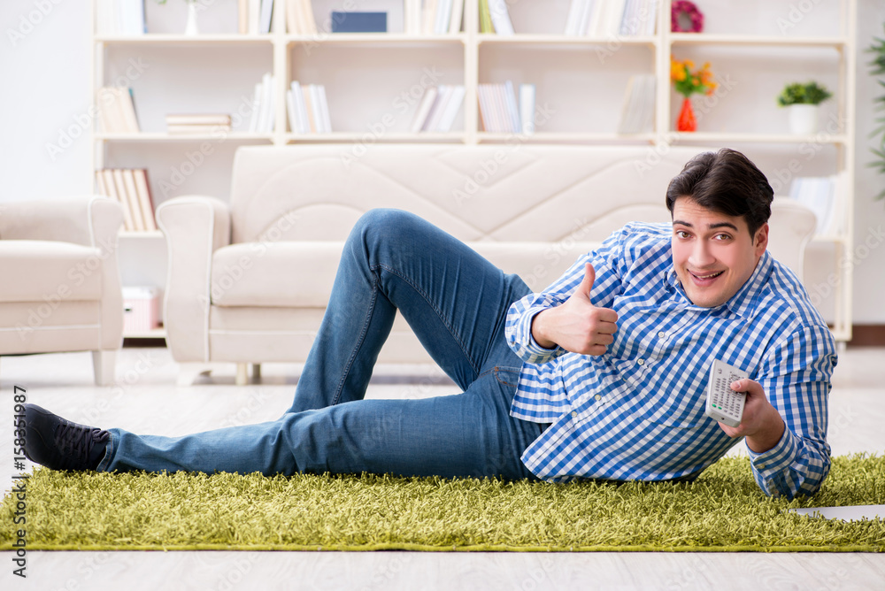 Fototapeta premium Young handsome man sitting on floor at home