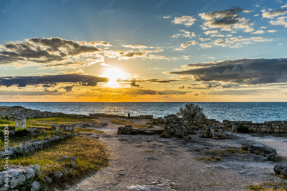 Sunset over the sea in the ancient Chersonesos among the ruins and buildings