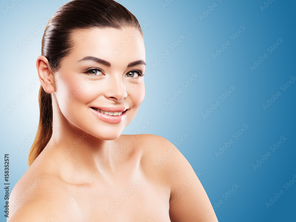 Beautiful Smiling Caucasian Woman with Clean Fresh Skin close up. Young model on blue background
