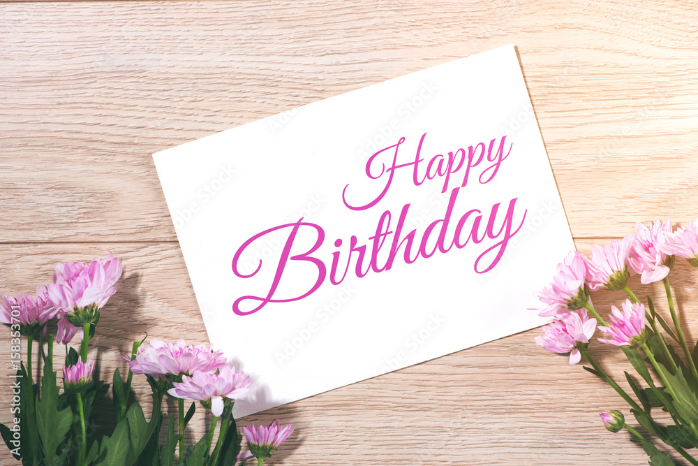 Pink flowers and empty paper for your text on wooden background Pink flowers and empty paper for your text on wooden background