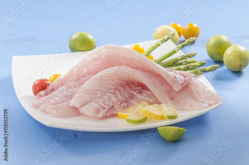 raw white fish fillets with tomatoes and fresh oregano & Lemon slice 