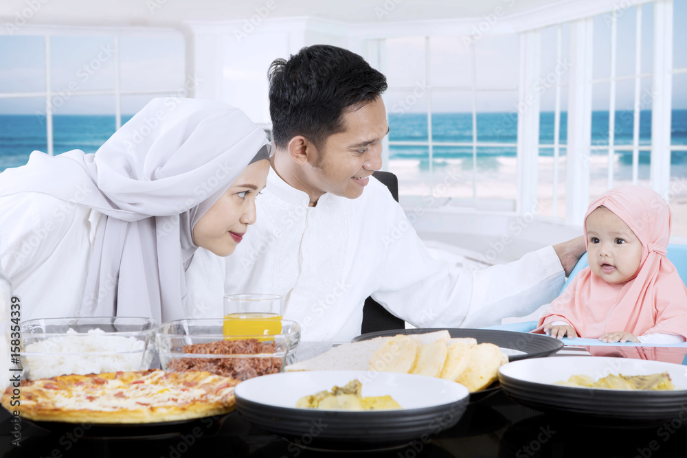 Young parents and girl having meal together Young parents and girl having meal together
