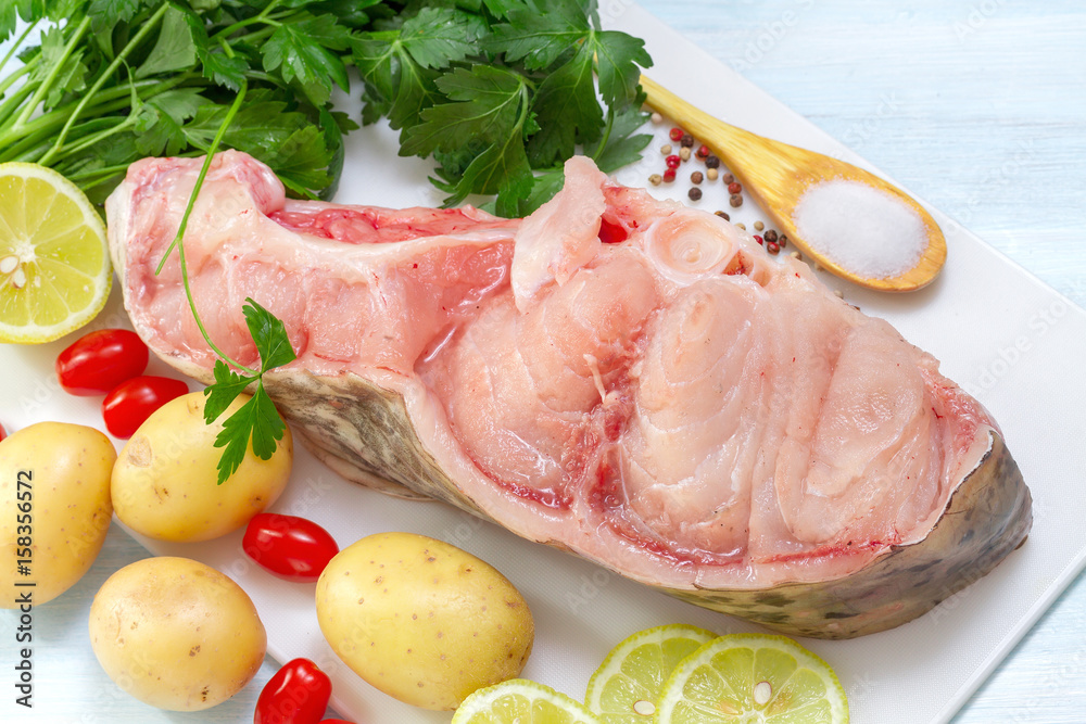 Raw Catfish with herbs and spices on table Raw Catfish with herbs and spices on table