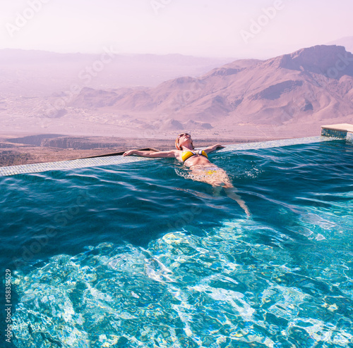The girl in the pool amid a beautiful mountain landscape