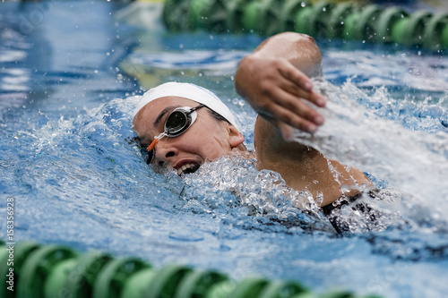 Chica practicando el deporte de la natación en piscina de verano estilo crol