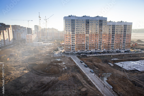 Construction of houses in a new neighborhood, yellow construction cranes © Mak
