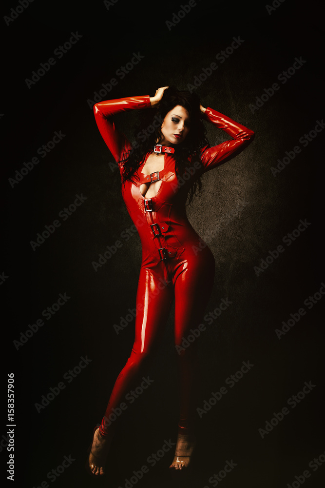 Jeune femme sexy en combinaison latex rouge, les mains dans les cheveux  Stock Photo | Adobe Stock