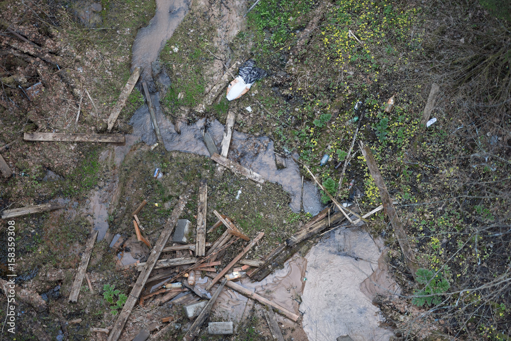 Damaged landscape of river bank with small river. Water polluted with mud due to landslide Damaged landscape of river bank with small river. Water polluted with mud due to landslide