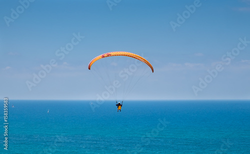Paragliding above Mediterranean sea on blue sky background