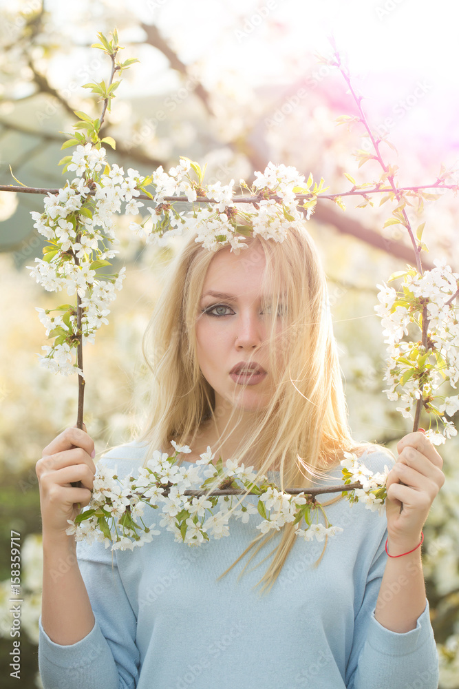 woman holding frame of white, blossoming flowers woman holding frame of white, blossoming flowers