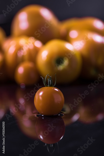  Yellow tomatoes on black background  water drops   mirror