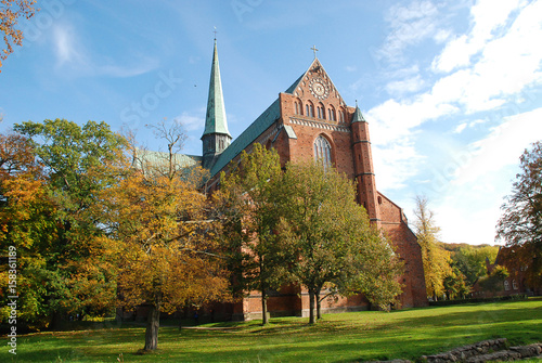 Minster in Bad Doberan (Germany), autumn trees with yellow leaves in the park of the church