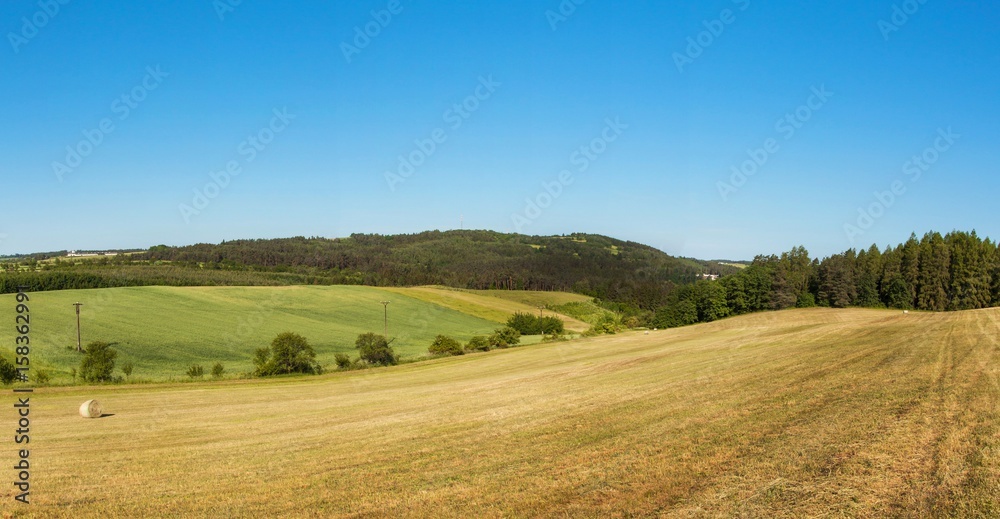 Panorama of a hilly forested landscape near the town of Tisnov in the Czech Republic. A sunny morning in the pasture.