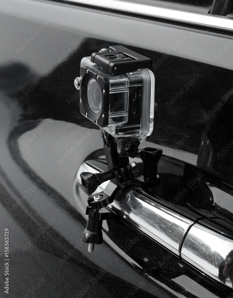Fototapeta premium action camera in the protective box is fixed on the car door handle