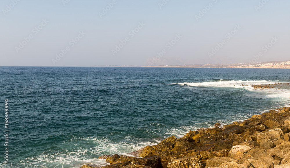 azure sea is broken on the stony shore on a clear sunny day Greece Crete Island azure sea is broken on the stony shore on a clear sunny day Greece Crete Island