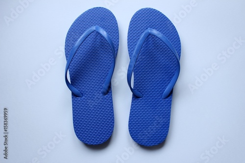 Des paires de chaussures de plage tong en couleurs sur fond blanc